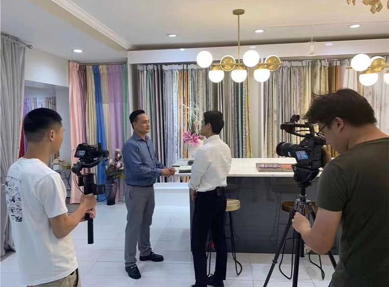 A crew of photographers taking photos of  two business men in a room full of drapery samples